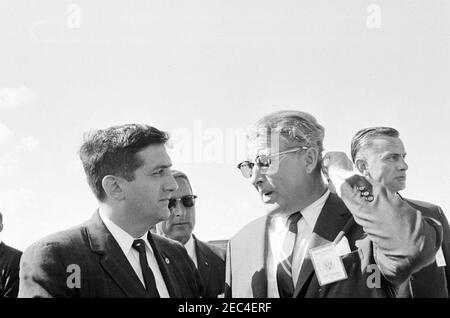 Visita delle installazioni della NASA: Cape Canaveral Florida, 14:31. Direttore del George C. Marshall Space Flight Center (MSFC), Dr. Wernher von Braun (a destra), parla con un uomo non identificato durante la visita del presidente John F. Kennedyu0027s alla stazione dell'aeronautica di Cape Canaveral, Cape Canaveral, Florida; l'agente del Servizio segreto della Casa Bianca, Roy Kellerman, si trova dietro la destra. Il presidente Kennedy ha visitato Cape Canaveral come parte di un tour di ispezione di due giorni delle installazioni sul campo della National Aeronautics and Space Administration (NASA). Foto Stock