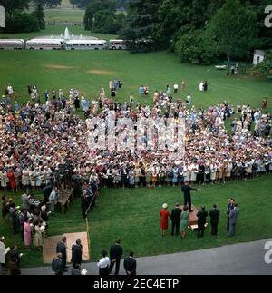 Visita dei partecipanti alla Conferenza della Campagna 1962 per le Donne democratiche, alle 9:35. Il presidente John F. Kennedy (in basso a destra, sulla piattaforma) commenta i partecipanti alla Conferenza della Campagna per le Donne democratiche del 1962. Nella foto sono inoltre raffigurati: Vice-Presidente del Comitato Nazionale Democratico (DNC), Margaret B. Price; Vice Presidente Lyndon B. Johnson; First Lady Jacqueline Kennedy; Senatore Hubert H. Humphrey (Minnesota); Senatore Mike Mansfield (Montana); Senatore George Smathers (Florida); Rappresentante Hale Boggs (Louisiana); Rappresentante Carl Albert (Oklahoma); corrispondente di Washington per il Minnesota Foto Stock