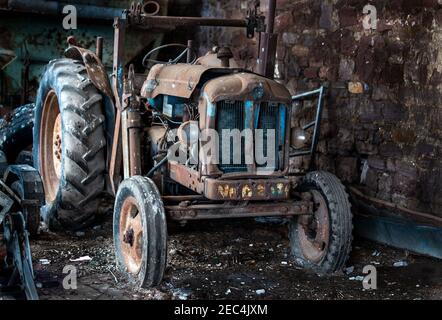 Un vecchio Fordson Power Major che è stato costruito tra il 1958 e 1961 cercando dispiaciuto e trascurato in una vecchia fattoria edificio Foto Stock