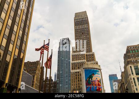 Bandiere e edifici americani sulla 7th Avenue mentre si va Fashion Avenue e il cartellone pubblicitario scritto 'Made of Italy' su di esso Foto Stock