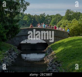 San Pietroburgo, Russia -- 22 luglio 2019. Foto di un gruppo turistico che attraversa un ponte sui terreni del palazzo estivo a San Pietroburgo, Russia. Foto Stock