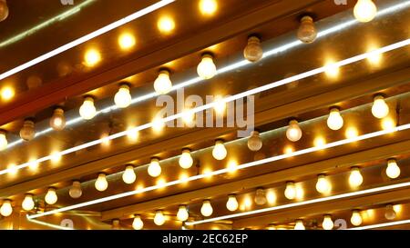 Le vecchie lampade elettriche che funzionano lampeggiano e si illuminano di notte. Primo piano astratto della decorazione del casinò retrò scintillante a Las Vegas, Stati Uniti. Luce di colore Foto Stock