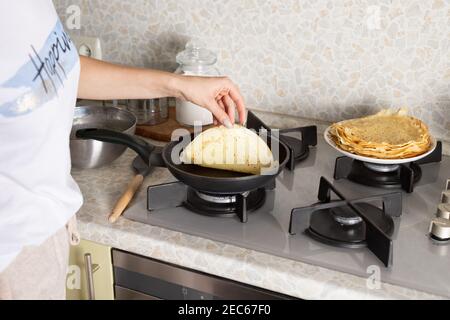 donna che fa le frittelle sottili, crepes. concetto domestico di cottura Foto Stock