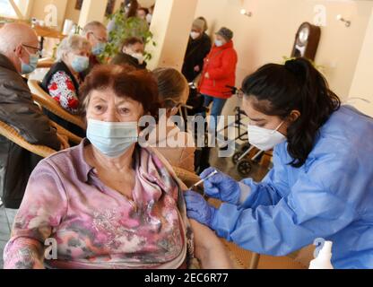 13 febbraio 2021, Sassonia, Lipsia: Anita Dutschke, 86 anni, riceve la vaccinazione corona da un dipendente di Johannitre-Unfall-Hilfe, nel complesso abitativo prefabbricato più lungo della Germania, nel sud-est della città. Un buon 200 di oltre 80 anni provenienti dall'edificio prefabbricato più lungo della Germania a Lipsia sarà vaccinato nel suo complesso di appartamenti il sabato. Si tratta di una prova in un complesso dove vivono molti anziani, secondo la Croce Rossa tedesca (DRK). Foto: Waltraud Grubitzsch/dpa-Zentralbild/dpa Foto Stock