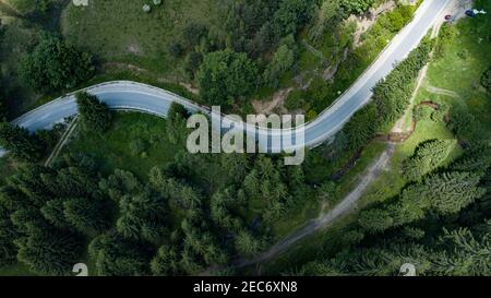 Vista dall'alto di una tortuosa strada collinare che passa attraverso a. terreno verde Foto Stock