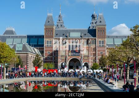 Persone di fronte al Tne Rijksmuseum e i amsterdam segno. Il Rijksmuseum è un museo nazionale olandese dedicato alle arti e alla storia di Amsterdam. Foto Stock