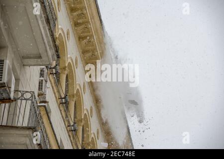 Mosca, Russia, 13 febbraio 2021: Una squadra di lavoratori pulisce il tetto di un edificio dalla neve con pale dopo una pesante nevicata Foto Stock