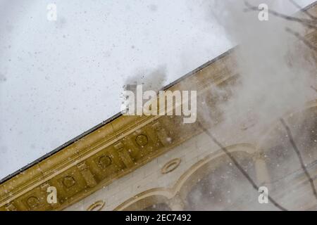 Mosca, Russia, 13 febbraio 2021: Una squadra di lavoratori pulisce il tetto di un edificio dalla neve con pale dopo una pesante nevicata Foto Stock