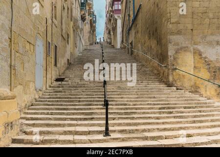 Tipica stradina in pietra con scale nel centro storico medievale di Valletta, sull'isola di Malta Foto Stock