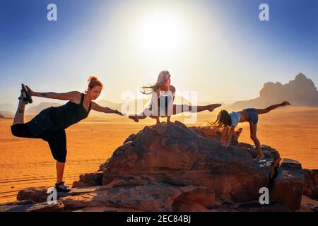 I turisti che fanno esercizi ginnici nel deserto del Wadi Rum Giordania Foto Stock