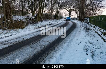 Van che guida curva rotonda su neve coperta strada di campagna in inverno, East Lothian, Scozia, Regno Unito Foto Stock