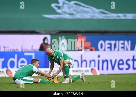 Brema, Germania. 13 Feb 2021. Oemer Toprak (Brema) si stende il piede di Ludwig Augustinsson (Brema). GES/Calcio/1. Bundesliga: Werder Bremen - SC Freiburg, 13 febbraio 2021 Calcio: Campionato: Squadra vs squadra, Località, 13 febbraio 2021 | usage worldwide Credit: dpa/Alamy Live News Foto Stock