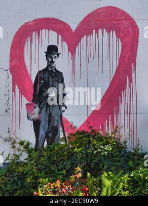 Carmel, Stati Uniti. 12 Feb 2021. Graffiti in stile californiano di un cuore e Charlie Chaplin esposti sulla parete del giardino all'interno dei terreni del Cypress Inn nel Carmel centrale, CA., USA l'Inn era una volta di proprietà della leggenda di Hollywood Doris Day. Credit: Motofoto/Alamy Live News Foto Stock