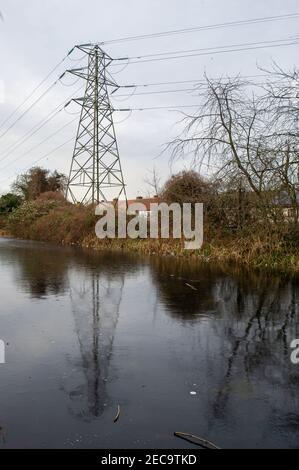 Slough, Berkshire, Regno Unito. 13 febbraio 2021. Un riflesso di un pilone elettrico in ghiaccio sulla cima del canale. A seguito di temperature gelide negli ultimi giorni, il braccio Slough del Canal Grande Union si è congelato oltre che sotto i ponti. Le temperature sono impostate per aumentare di nuovo la settimana prossima, mettendo fine al freddo. Credit: Maureen McLean/Alamy Live News Foto Stock