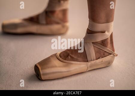Primo piano dei piedi di una ballerina che indossano scarpe appuntite su un sfondo bianco Foto Stock