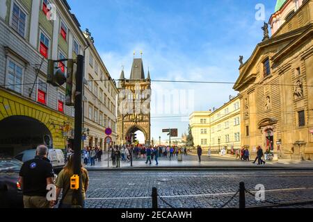 I pedoni si preparano ad attraversare la strada verso Piazza dei Cavalieri della Croce con la Torre della Città Vecchia e la Cattedrale di San Vito in vista della Czechia di Praga. Foto Stock