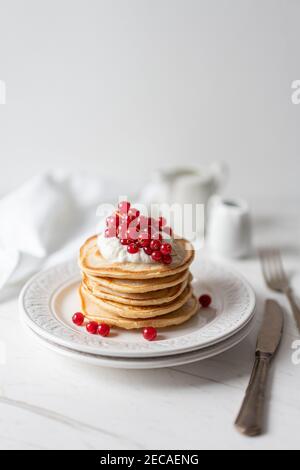 Frittelle di arachidi americane con mirtilli rossi, sciroppo d'acero e yogurt, Morning Flat Lay Foto Stock