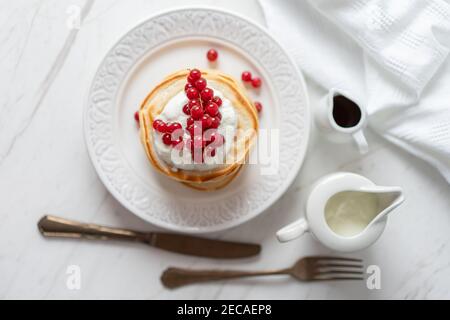 Frittelle di arachidi americane con mirtilli rossi, sciroppo d'acero e yogurt, Morning Flat Lay Foto Stock