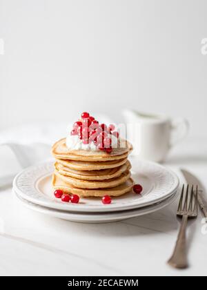 Frittelle di arachidi americane con mirtilli rossi, sciroppo d'acero e yogurt, Morning Flat Lay Foto Stock