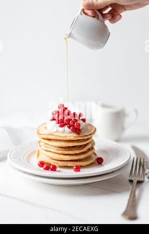 Frittelle di arachidi americane con mirtilli rossi, sciroppo d'acero e yogurt, Morning Flat Lay Foto Stock