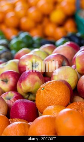 Mercato agricolo, mele rosse e gialle, arance, fresche e colorate, in esposizione. Foto Stock