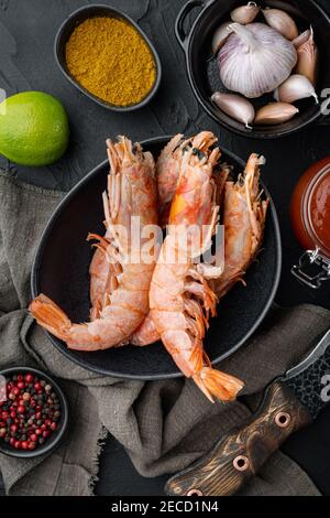 Barbecue crudo grigliare gamberi argentini rossi ingredienti impostati in ciotola, su sfondo nero, vista dall'alto piatto Foto Stock