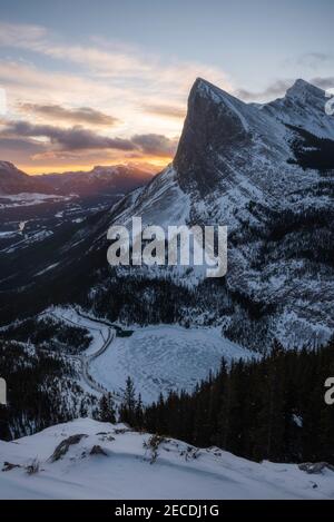 Una bella alba invernale a Canmore, Alberta vista da un'escursione fino all'estremità orientale del Monte Rundle guardando verso ha Ling Peak. Foto Stock