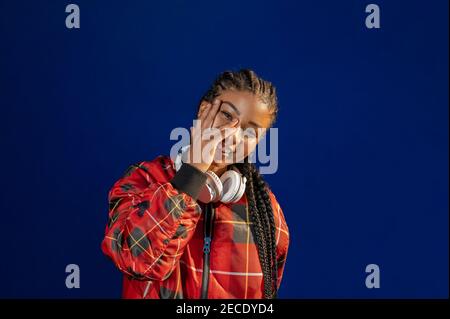 Bella giovane afroamericana femmina sorridente felice su sfondo blu Foto Stock