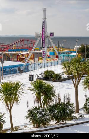 Parco a tema Adventure Island a Southend on Sea, Essex, Regno Unito, con neve da Storm Darcy. Axis emozionante corsa e palme con strato di neve Foto Stock