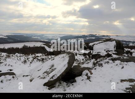 Neve coperta Derbyshire mulino pietra taglio da Millstone Grit in Il Peak District National Park Foto Stock