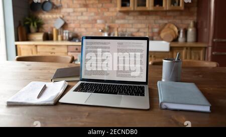 Primo piano su un computer portatile moderno su un tavolo di legno con notebook Foto Stock