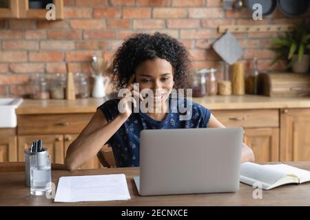 Primo piano sorridente afroamericana che parla al telefono Foto Stock