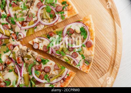 Pizza vista dall'alto tagliata su 8 pezzi e una spinta in avanti. Pubblicità per pizzeria, caffè e ristorante. Fornitura di cibo al concetto di quarantena covid-19. Foto Stock