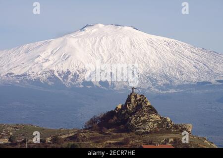 Etna in Sicilia montagna cima innevata statua 'Cristo Signore Della montagna' sulla roccia nella città di Cesarò del Parco dei Nebrodi Foto Stock