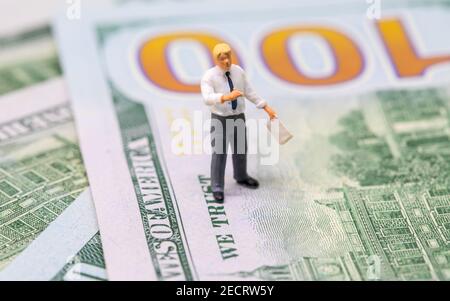 Figurine uomo d'affari su banconota da dollaro. Uomo di affari sta sul concetto di soldi. Economia moderna e crescita finanziaria. Uomo d'affari che spiega la strategia. Foto Stock