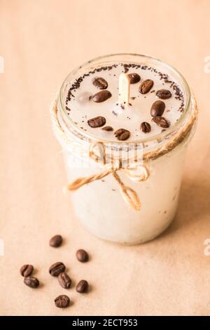 Concetto DIY. Candela profumata fatta a mano con chicchi di caffè in un vaso di vetro. Foto Stock