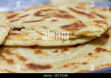 Pane pita fresco. Il pezzo di pane viene spezzato in due pezzi. Messa a fuoco selettiva. Foto Stock