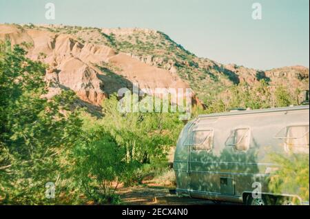 Un RV vintage retro parcheggiato in una fitta foresta durante un viaggio di vacanza Foto Stock