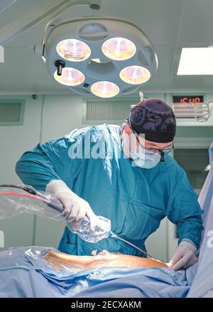 chirurgo durante la liposuzione nella sala operatoria Foto Stock