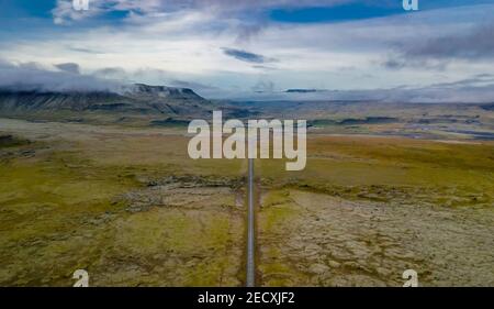 Vista aerea di un paesaggio islandese con una strada in il centro Foto Stock