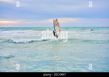 Winter Windsurf, l'uomo in muta windsurf in inverno, in fondo si può vedere il bar ghiaccio Foto Stock