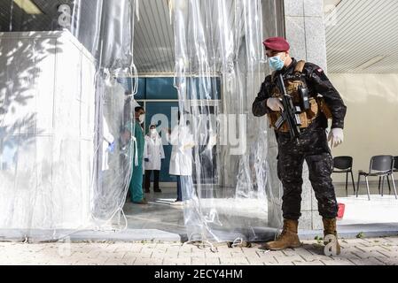 Beirut, Libano, 14 febbraio 2021. Una guardia armata all'ingresso del centro di vaccinazione dell'ospedale universitario di Rafik Hariri mentre il Libano inizia il suo programma di vaccino Covid-19 vaccinando il personale medico il giorno di San Valentino. Elizabeth Fitt Credit: Elizabeth Fitt/Alamy Live News Foto Stock