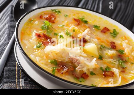 Polish zuppa di crauti Kapusniak con costolette e pancetta primo piano in un piatto sul tavolo. Orizzontale Foto Stock