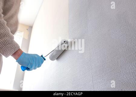 Uomo che dipinge la parete con un rullo di vernice. Fai da te concetto Foto Stock