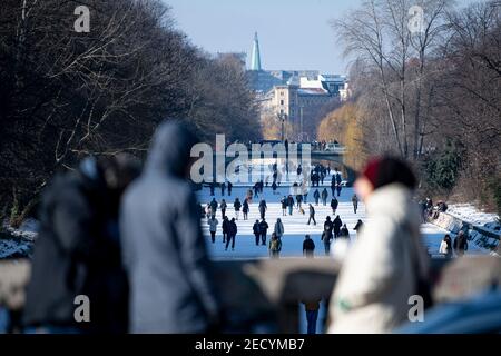 Berlino, Germania. 14 Feb 2021. Le persone approfittano del tempo soleggiato per attraversare a piedi il congelato Landwehrkanal. Credit: Fabian Sommer/dpa/Alamy Live News Foto Stock