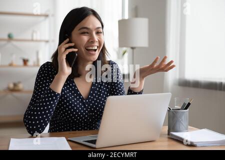 La storia di una donna asiatica era molto gioiosa per telefono prima dello schermo del computer Foto Stock