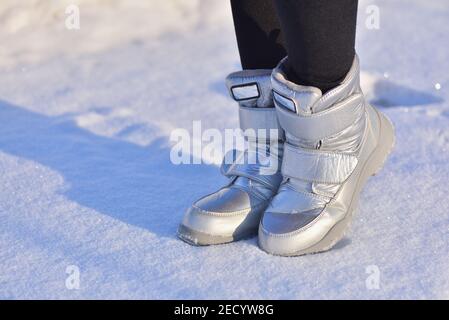 Stivali invernali per bambini in color argento sulla neve Foto Stock