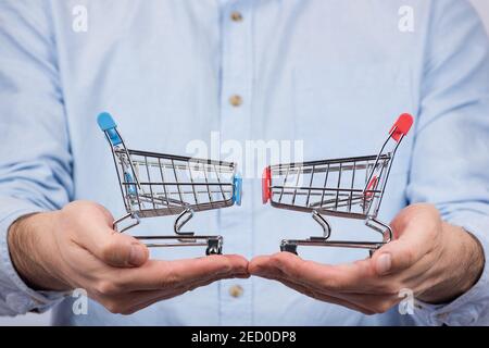 L'uomo tiene due carrelli di spinta della drogheria del supermercato. Acquistare il concetto di acquisto Foto Stock