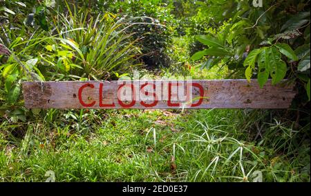 Cartello chiuso su tavola di legno nel soleggiato giardino estivo. Tavola di legno con l'iscrizione chiusa. Cartello rustico in legno con parola chiusa. Cancello o ingresso a. Foto Stock