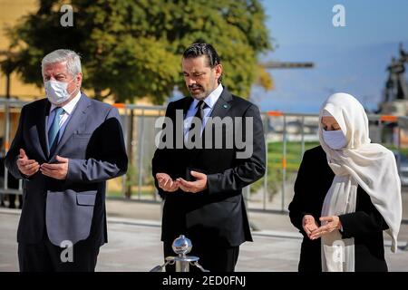 Beirut, Libano. 14 Feb 2021. Il libanese ha designato il primo ministro Saad Hariri (C) insieme a sua zia Bahia (R) e allo zio Shafiq recita i versetti del Santo Corano e ha deposto le corone presso la tomba del padre, il defunto primo ministro Rafiq al-Hariri, per celebrare il 16° anniversario del suo assassinio. Il 14 febbraio 2005, Rafiq al-Hariri fu assassinato in un massiccio attentato all'automobile intrappolata. Credit: Marwan Naamani/dpa/Alamy Live News Foto Stock